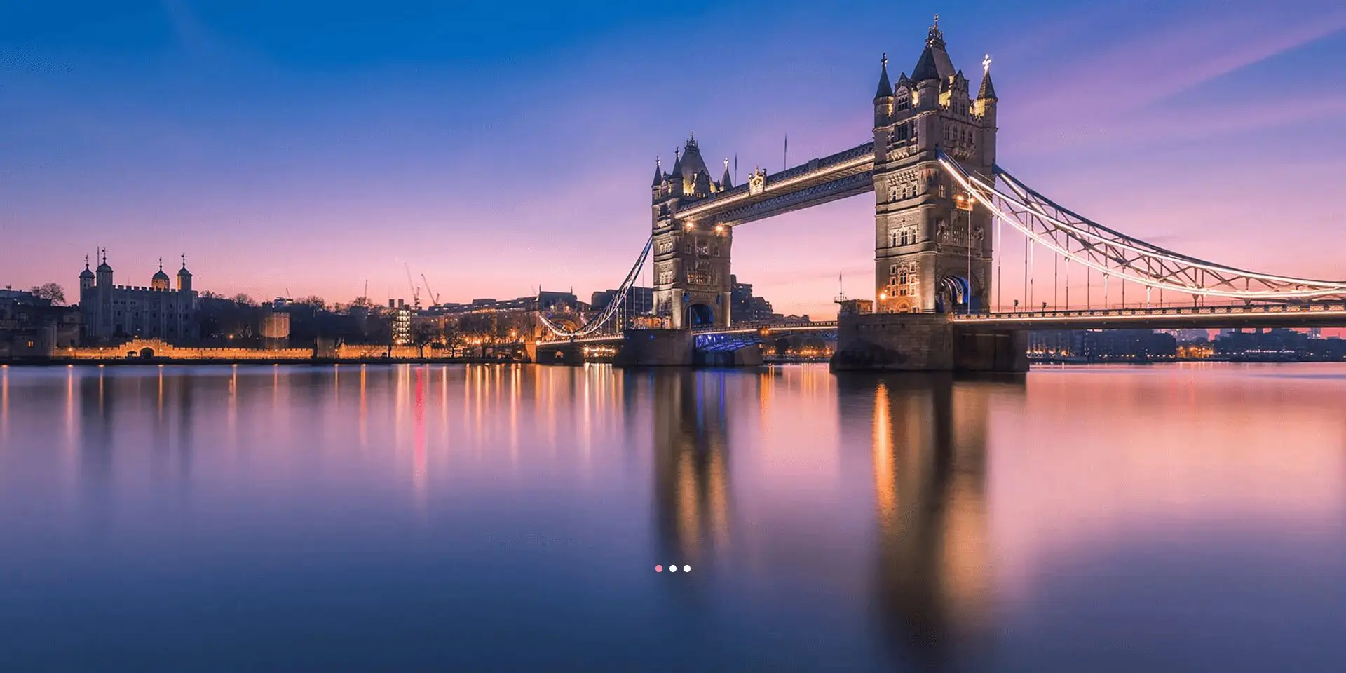 Tower Bridge at sunset over calm river.